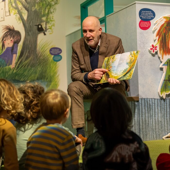 Directeur Meinderts van het Kinderboekenmuseum in Den Haag leest voor tijdens Voorleesontbijt 2024 aan kinderen van Kinderopvang 2Samen