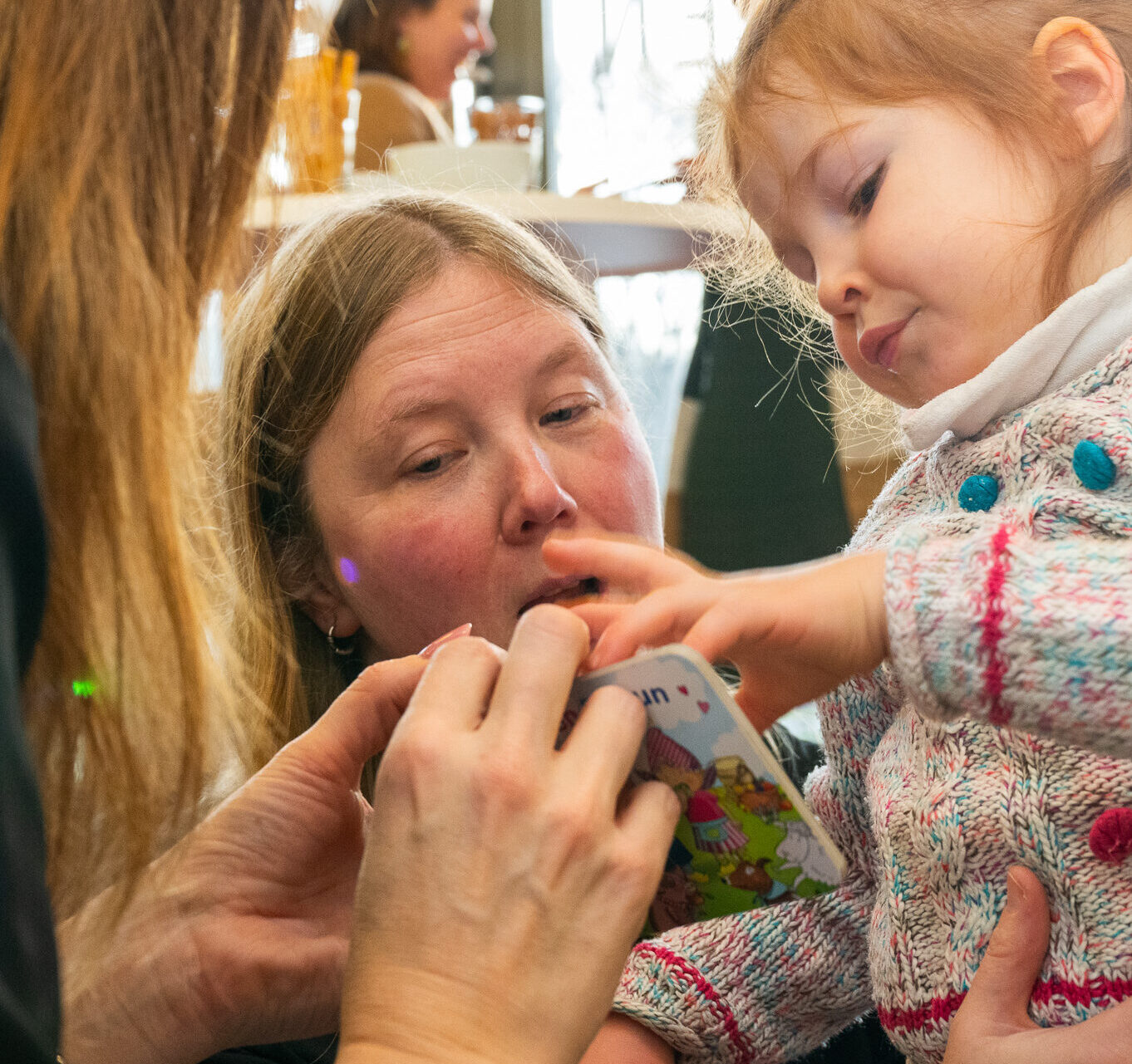 Izabella (3) kijkt een boekje met pedagogisch medewerker 2Samen Linda