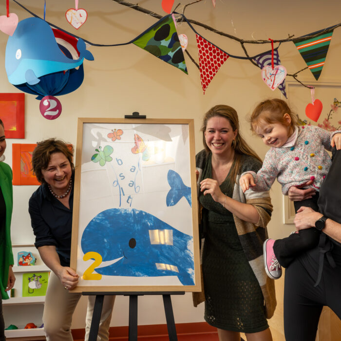 Izabella (3 jaar) onthult met pedagogisch medewerker en drie directeur bestuurders van Kinderopvang 2Samen, Kinderopvang Kombino en revalidatiecentrum Basalt een zelfgemaakt kunstwerk. Hiermee wordt het nieuwe kinderdagverblijf 2Walvissen geopend.