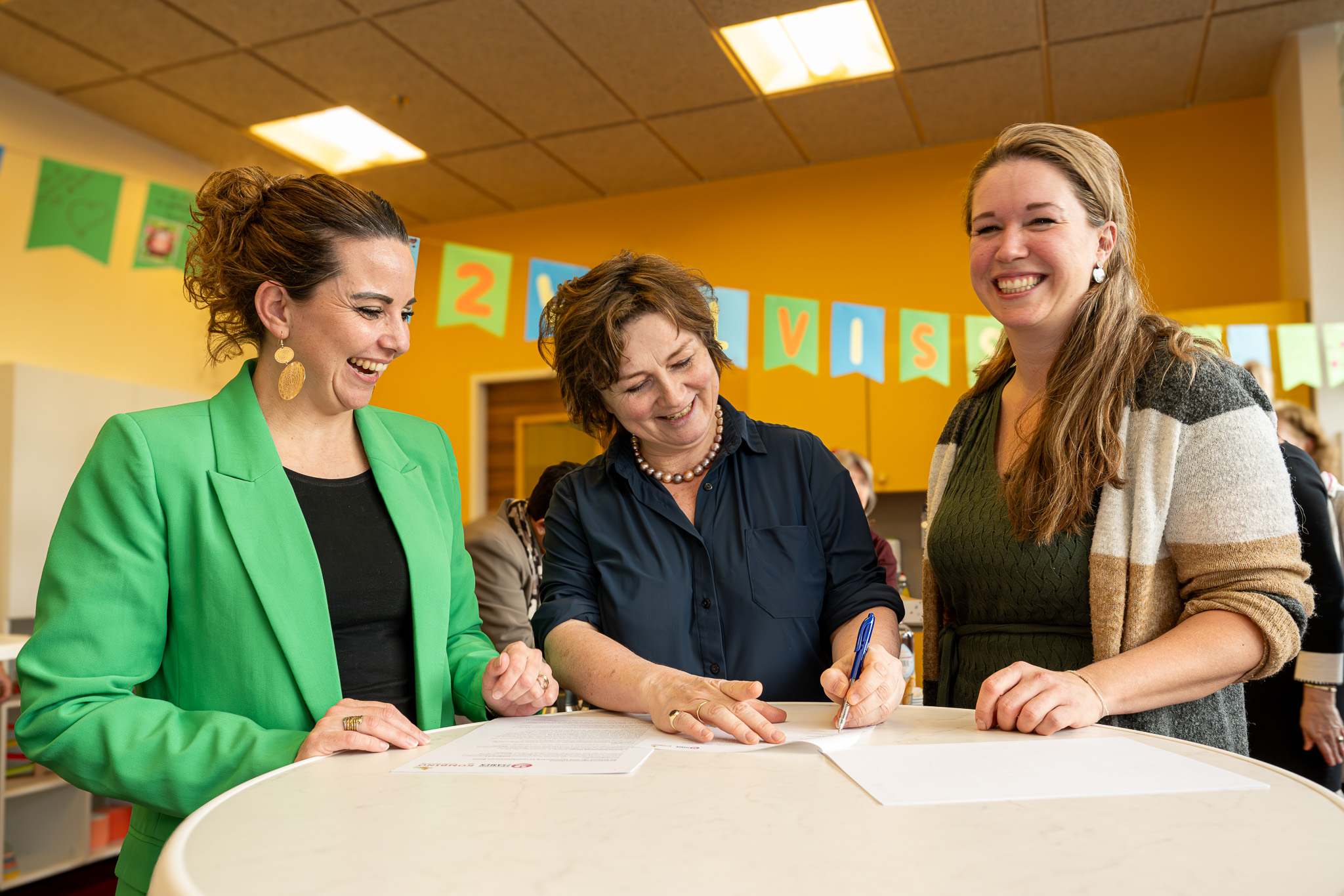 Zoë Kwint bestuurder 2Samen (midden) ondertekent de samenwerkingovereenkomst met Malou Jonker directeur Kombino (links). Rechts Nikie van den Berge bestuurder Basalt