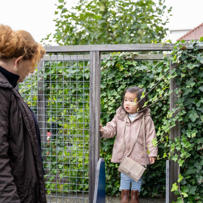 medewerker en kind op glijbaantje bij peuteropvang 2schuiten in wateringse veld den haag