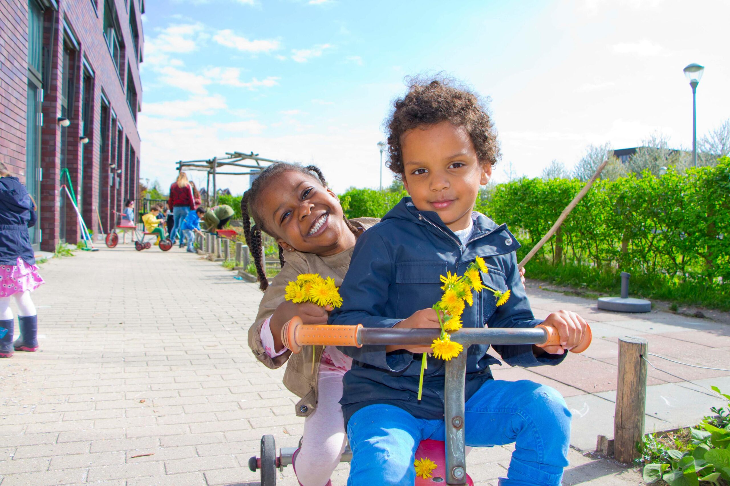 kinderen op driewieler Moestuin kinderdagverblijf 2Zwanen Ypenburg Den Haag Kinderopvang 2Samen