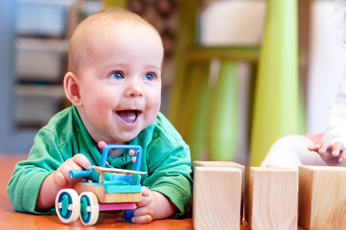 Baby speelt met houten speelgoed in kinderopvang 2Samen Den Haag Monster Naaldwijk