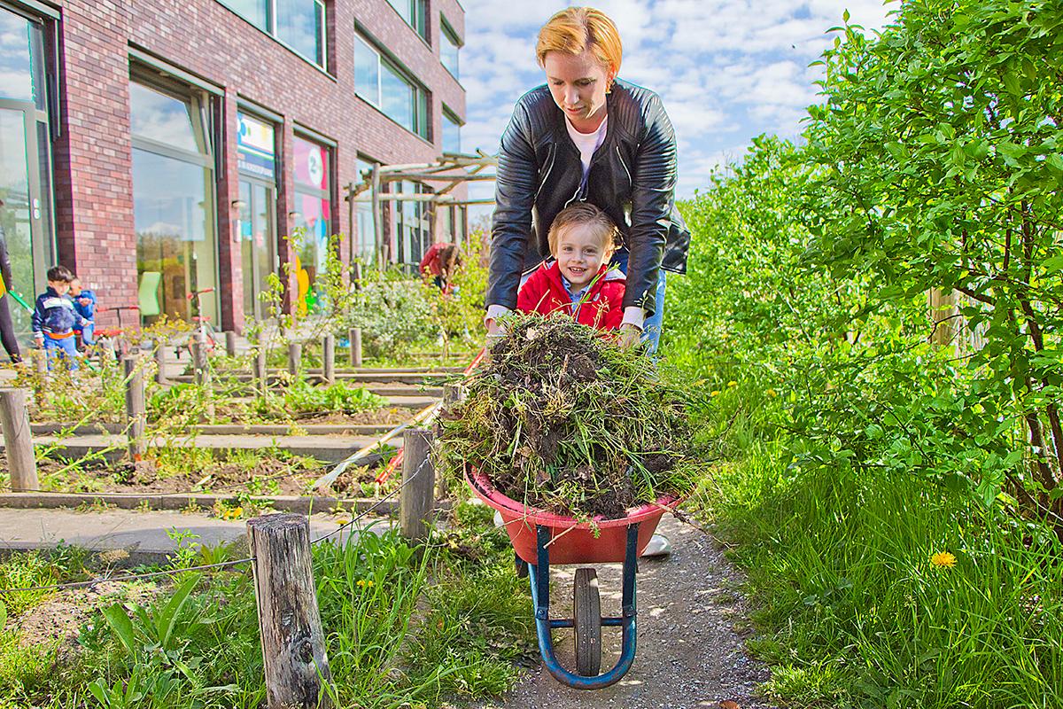 kind in kruiwagen Moestuin kinderdagverblijf 2Zwanen Ypenburg Den Haag Kinderopvang 2Samen