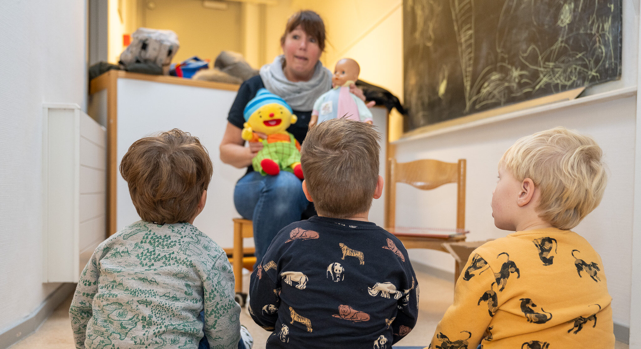 drie peuters bij voorschoolse educatie VE wordt met Puk en een babypop wat uitgelegd bij 2Ballonnen in Monster