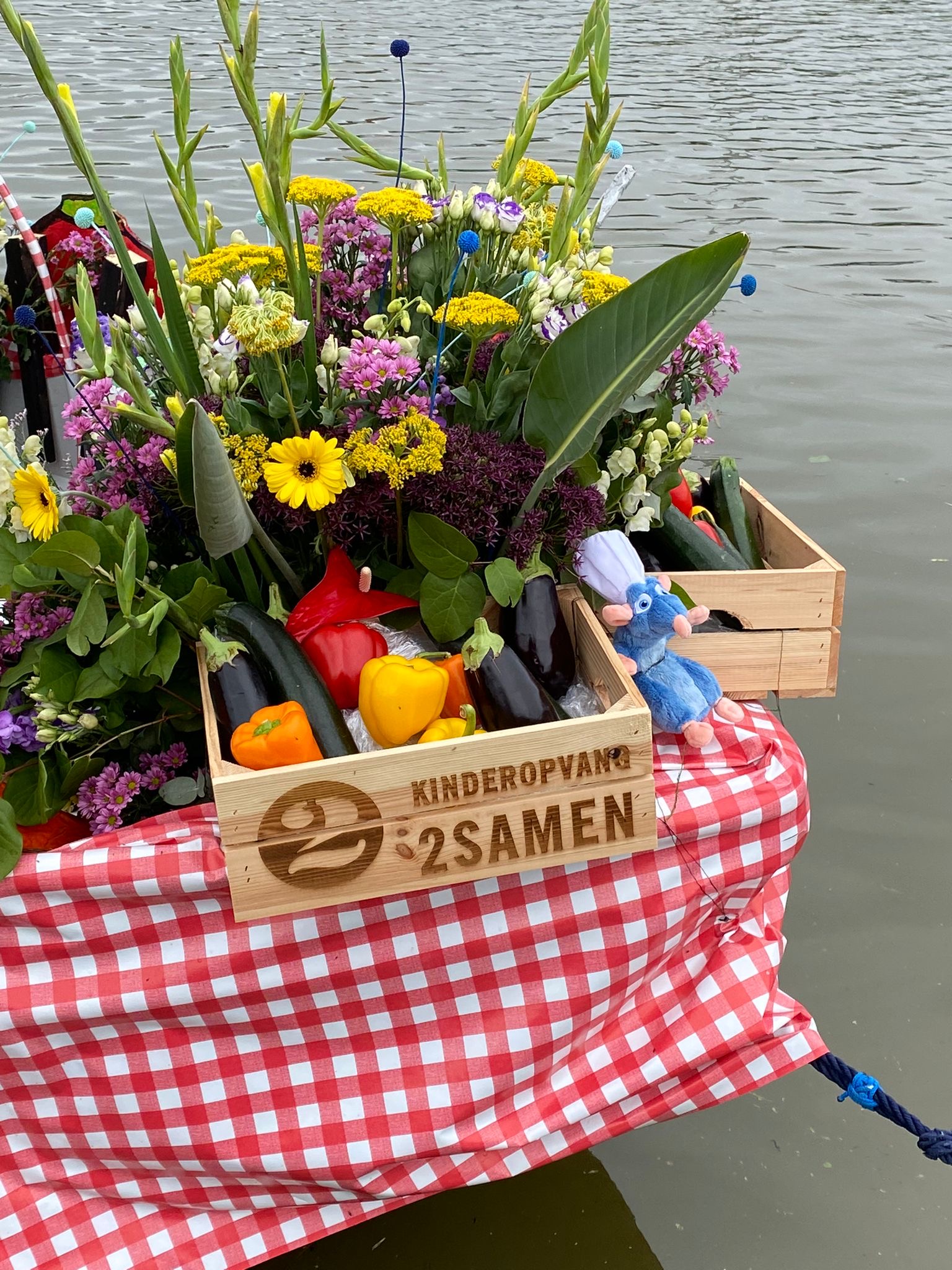 Muis Remy naast kleurrijke groente en bloemen op jeugdboot Ratatouille voor het Varend Corso 2024