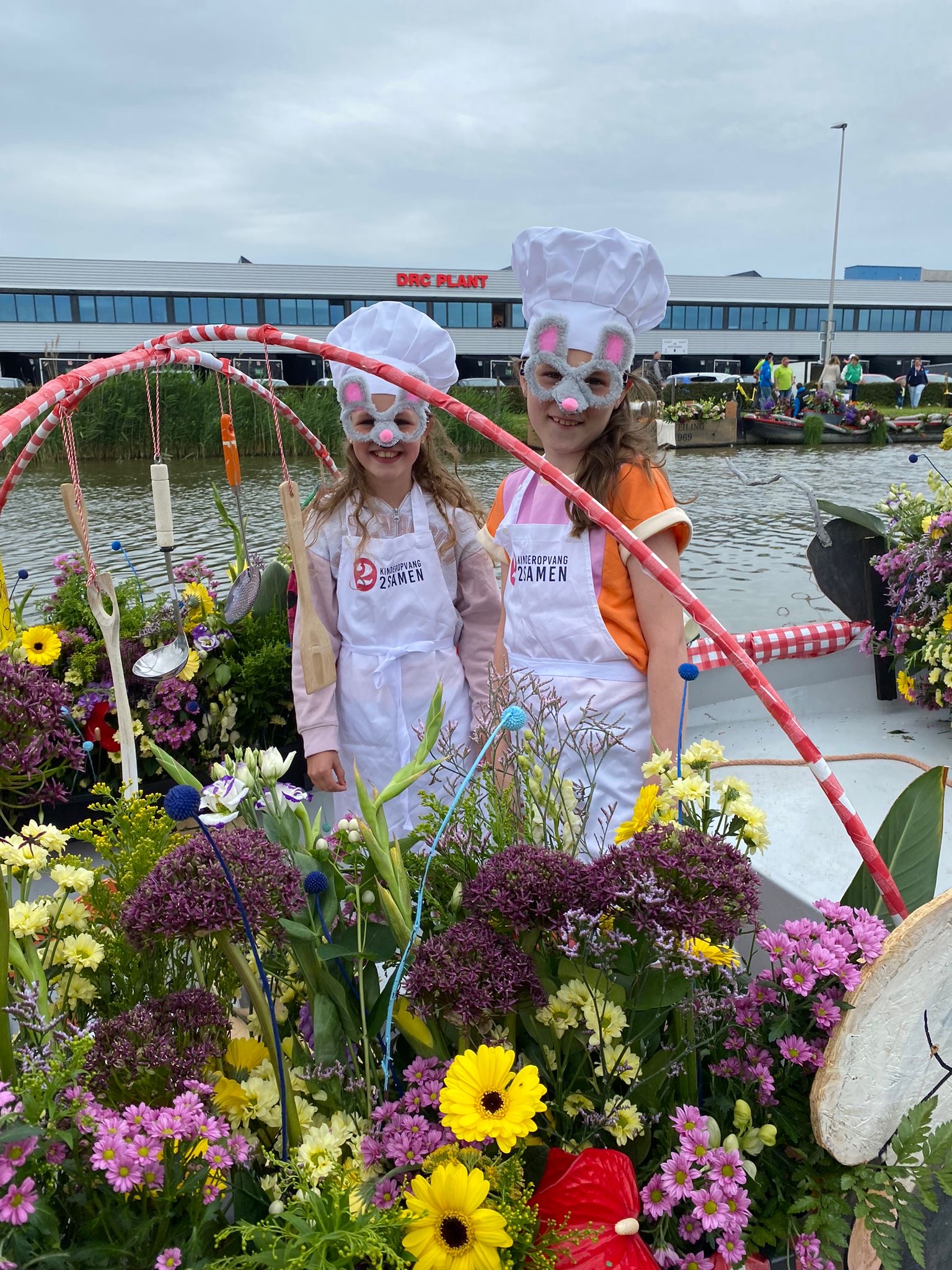 Twee bso-kinderen staan op de boot, als muizen verkleed met een koksmuts en schort om. Klaar voor de start van Varend Corso Westland 2024