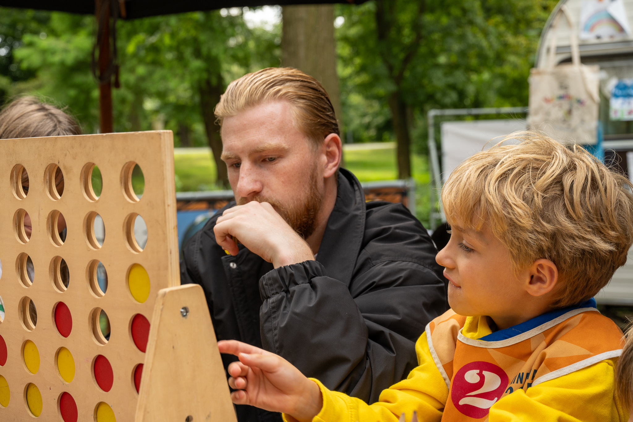 jongen en medewerker spelen spel in het vakantiepark