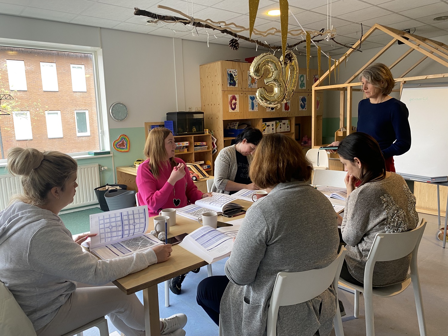 Taalles gratis met kinderopvang bij 2Onder Elkaar. Een van de vijf moeder die les krijgt reageert op een vraag van de docente.